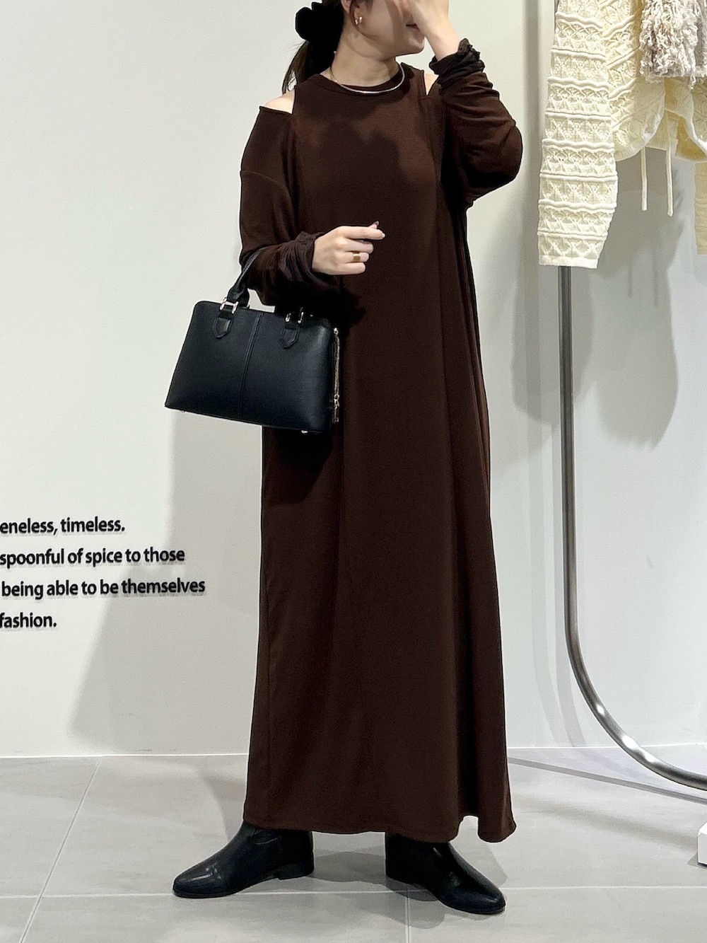 ブラック系のハンドバッグ、ブラウン系のワンピースを着用したレディースの秋コーディネートの2枚目の写真
