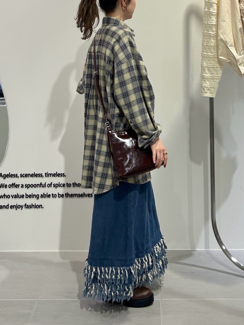 ブルー系のワンピース、イエロー系のシャツ/ブラウス、ブラウン系のショルダーバッグを着用したレディースの秋コーディネートの4枚目の写真