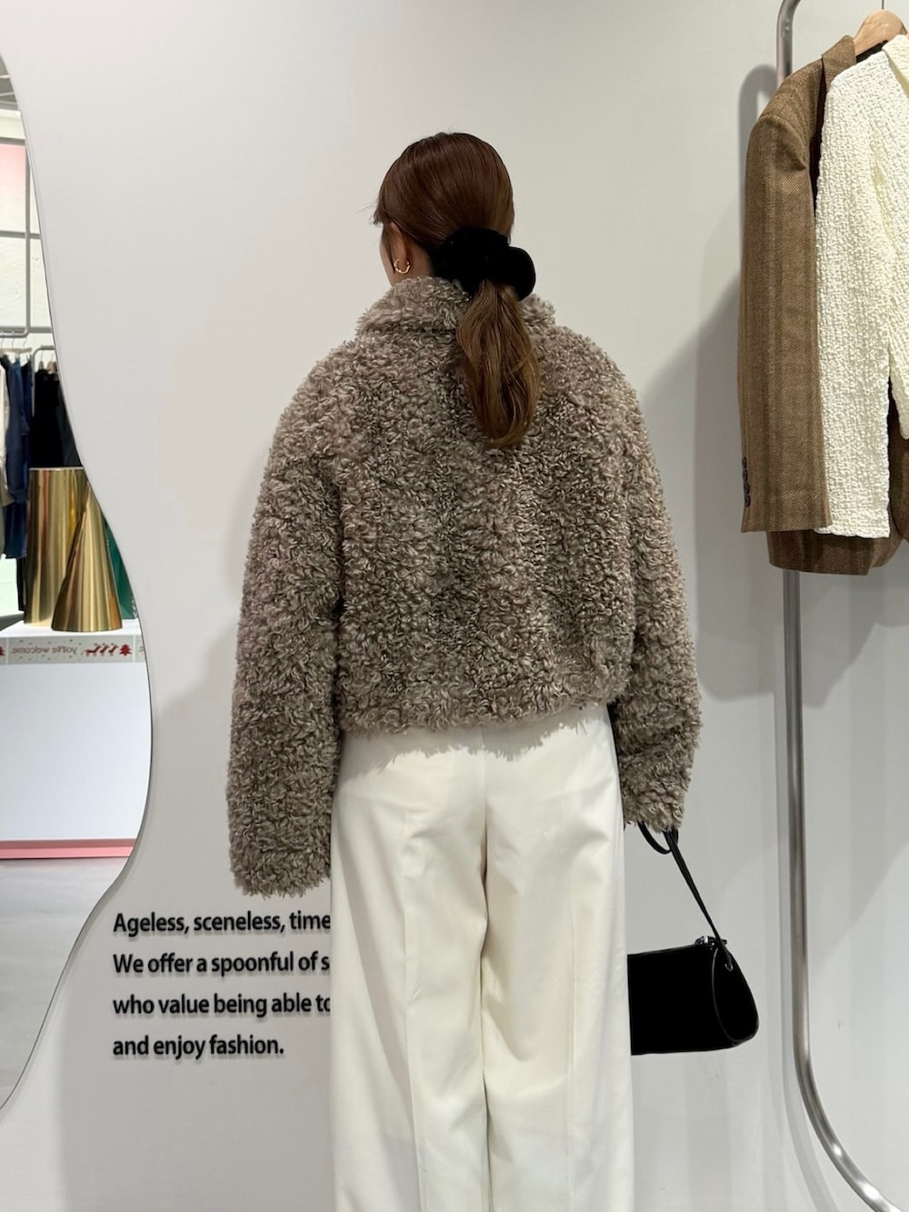 ベージュ系のその他アウター、ホワイト系のその他パンツ、ブラック系のショルダーバッグを着用したレディースの秋コーディネートの2枚目の写真