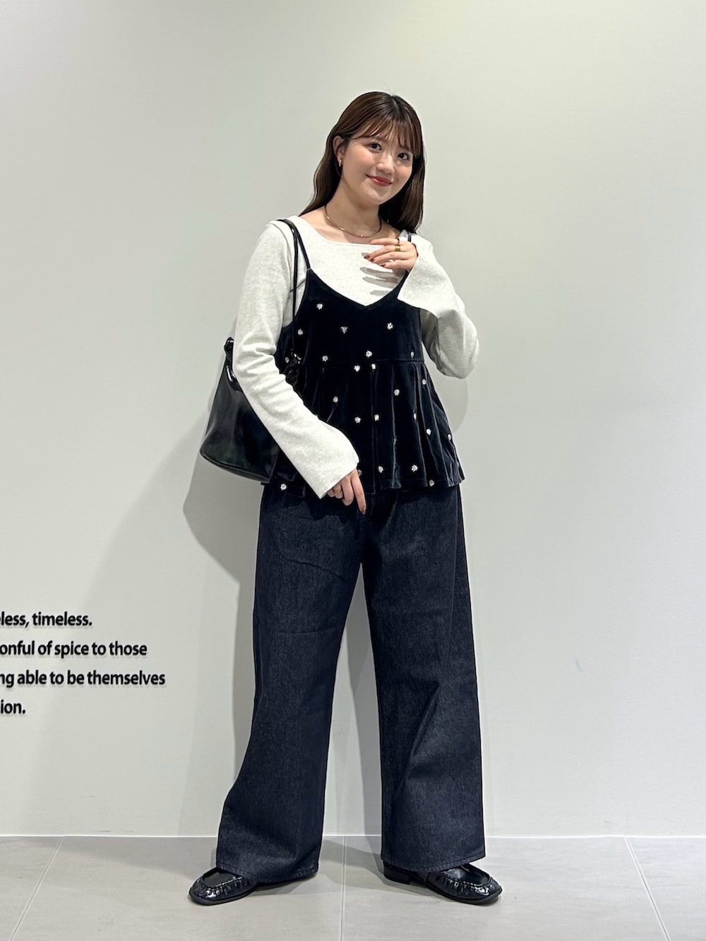 グレー系のキャミソール、グレー系のTシャツ/カットソー、ブルー系のデニムパンツを着用したレディースの秋コーディネートの3枚目の写真