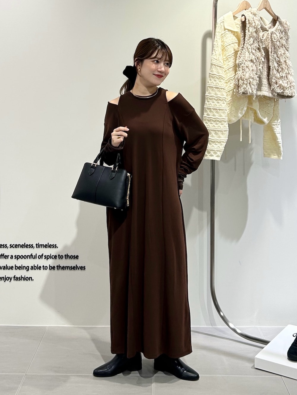 ブラック系のハンドバッグ、ブラウン系のワンピースを着用したレディースの秋コーディネートの6枚目の写真