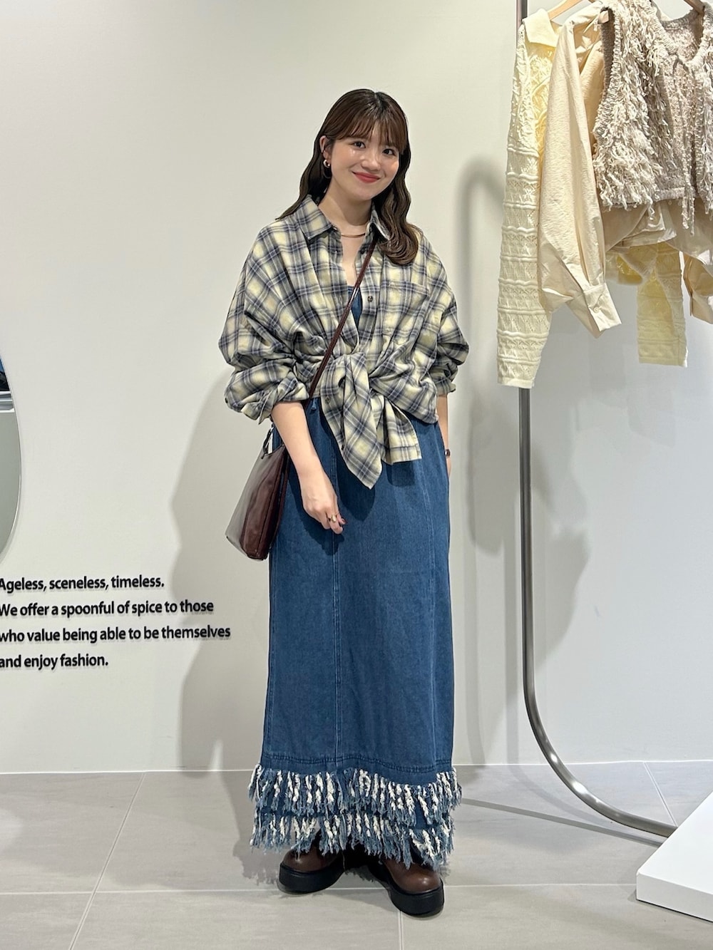 ブルー系のワンピース、イエロー系のシャツ/ブラウス、ブラウン系のショルダーバッグを着用したレディースの秋コーディネートの3枚目の写真