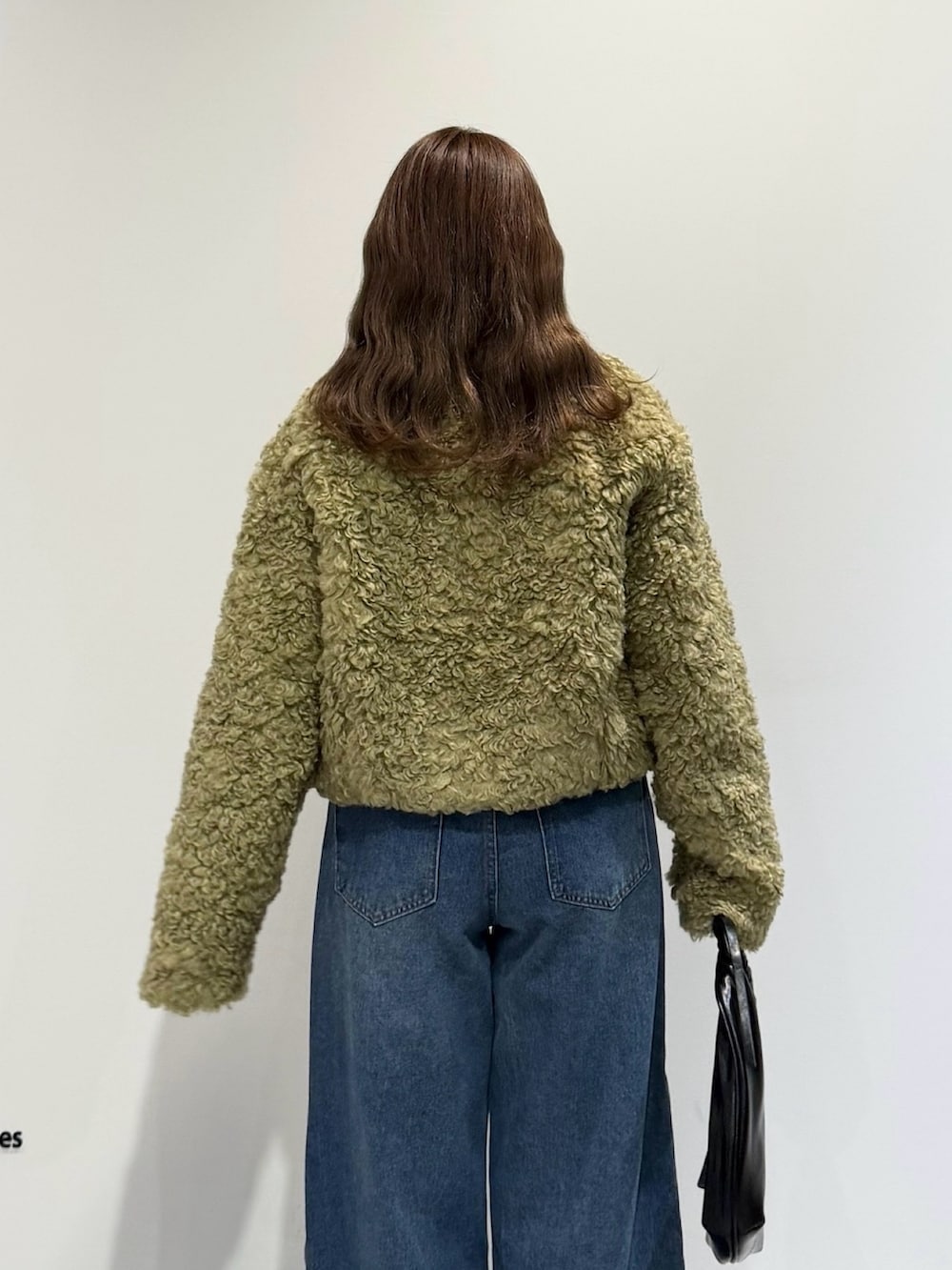 グリーン系のその他アウター、ブルー系のデニムパンツ、ブラック系のハンドバッグを着用したレディースの秋コーディネートの3枚目の写真