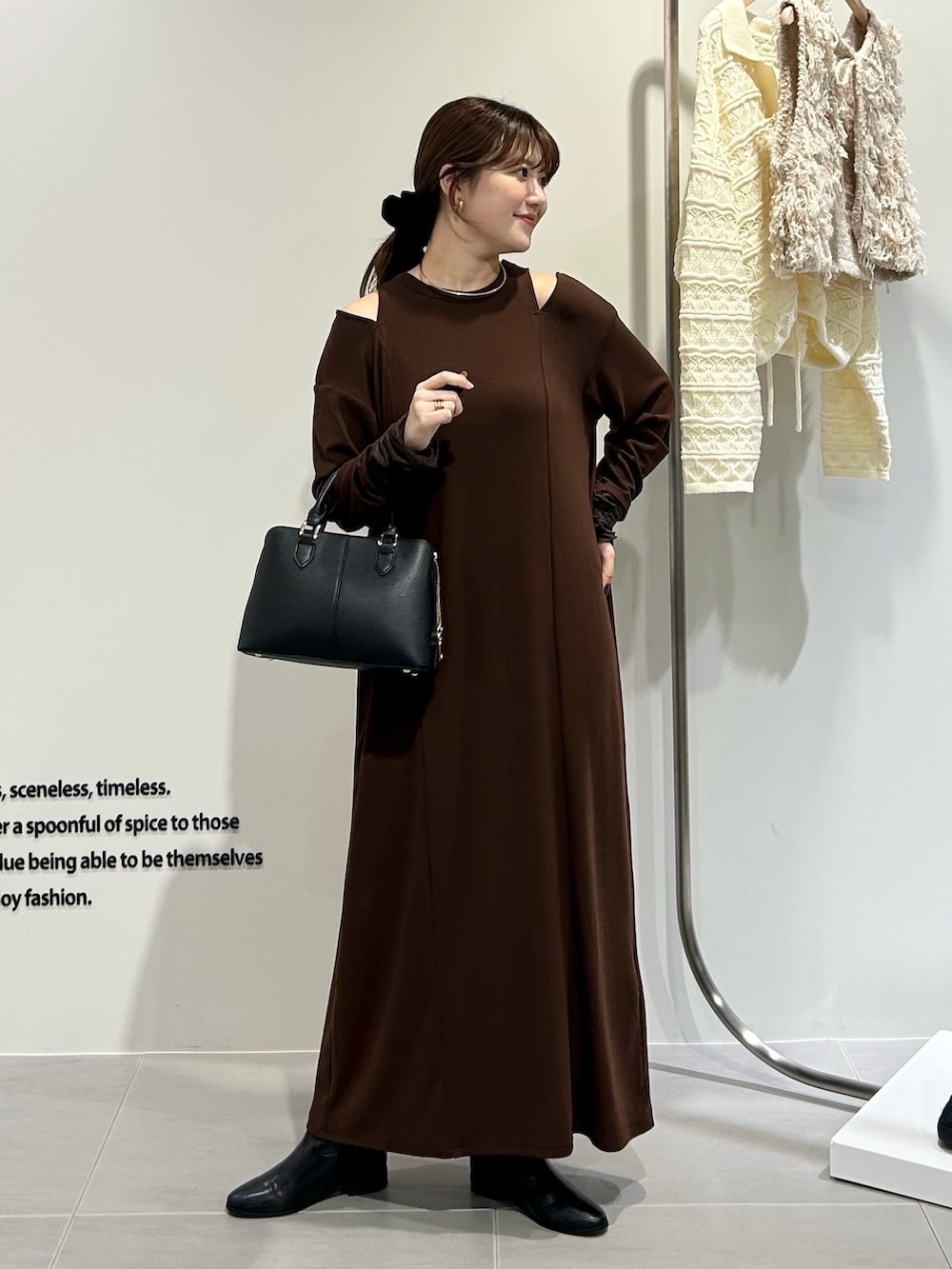 ブラック系のハンドバッグ、ブラウン系のワンピースを着用したレディースの秋コーディネートの4枚目の写真