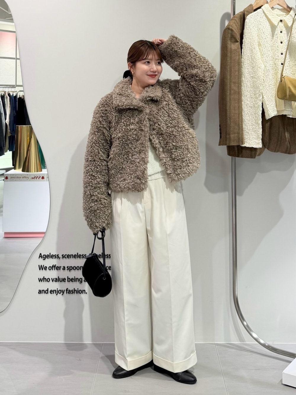 ベージュ系のその他アウター、ホワイト系のその他パンツ、ブラック系のショルダーバッグを着用したレディースの秋コーディネートの4枚目の写真