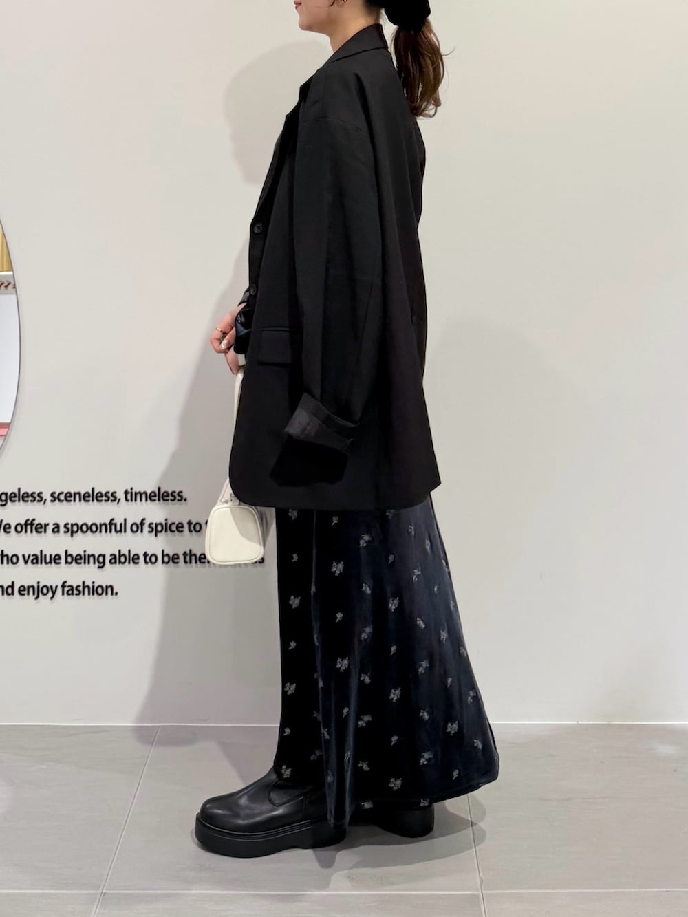 グレー系のワンピース、ブラック系のブーツ、ブラック系のその他アウターを着用したレディースの秋コーディネートの3枚目の写真