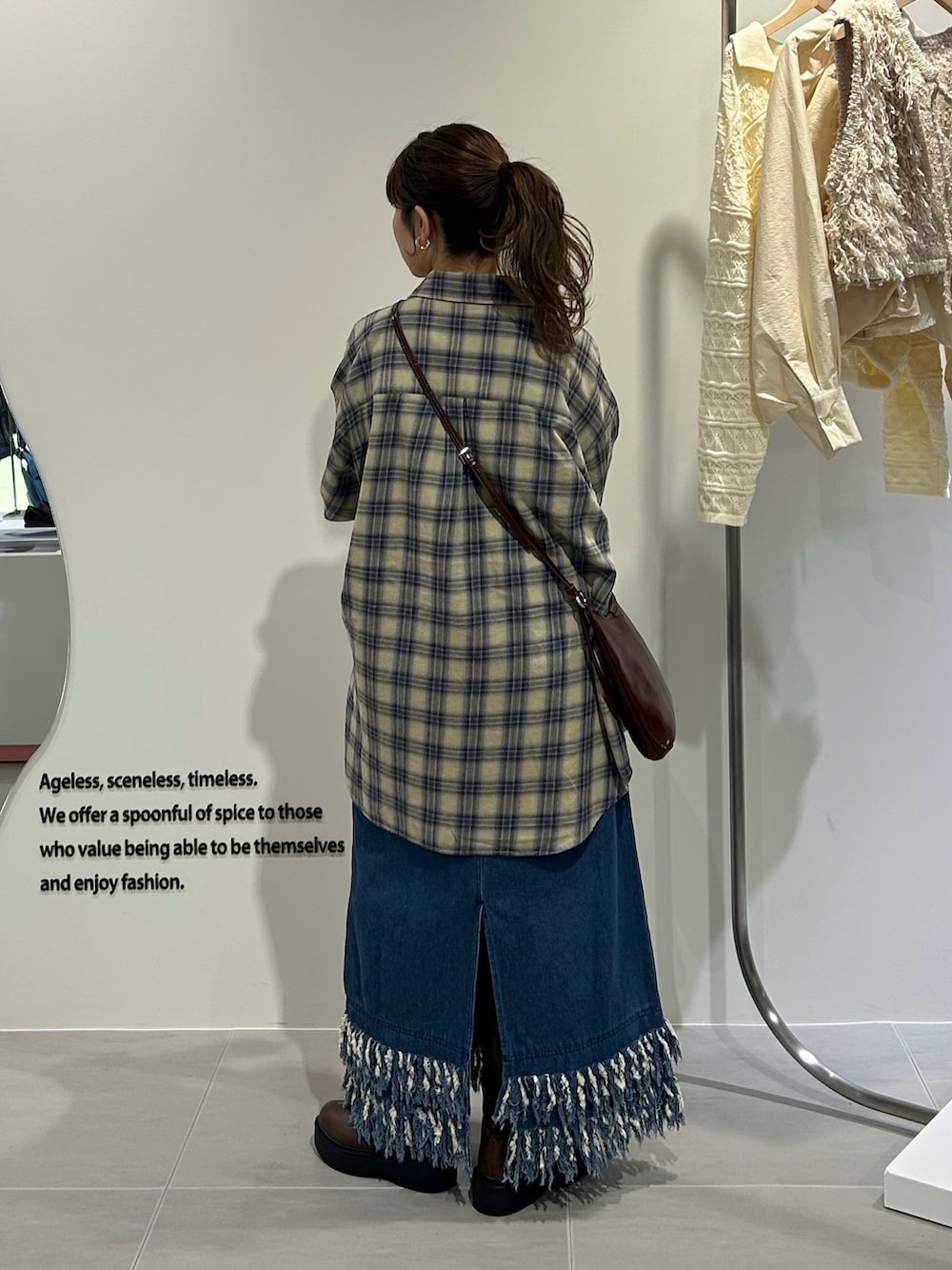 ブルー系のワンピース、イエロー系のシャツ/ブラウス、ブラウン系のショルダーバッグを着用したレディースの秋コーディネートの2枚目の写真