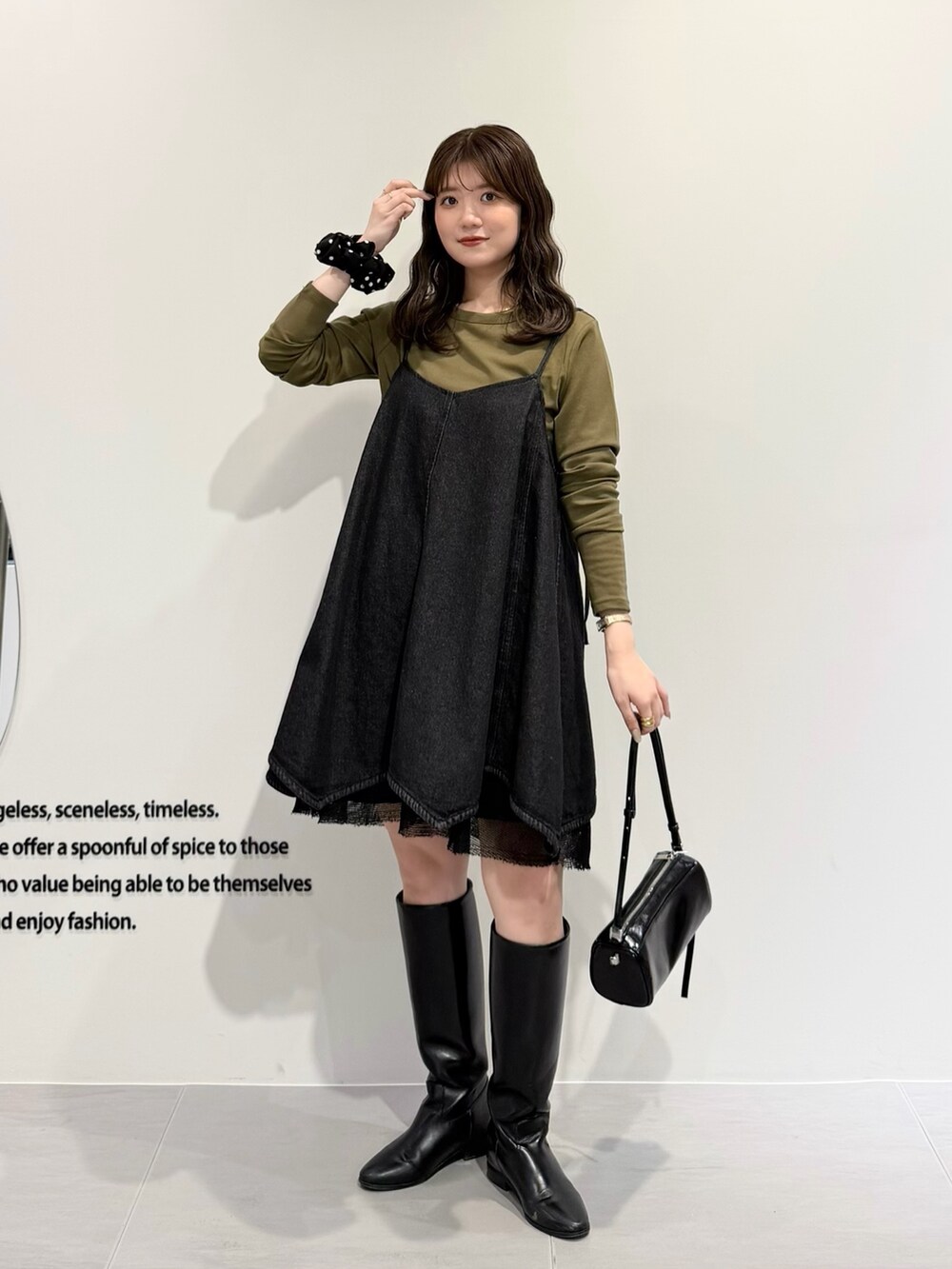 ブラック系のワンピース、グリーン系のTシャツ/カットソー、ブラック系のショルダーバッグを着用したレディースの春コーディネートの4枚目の写真