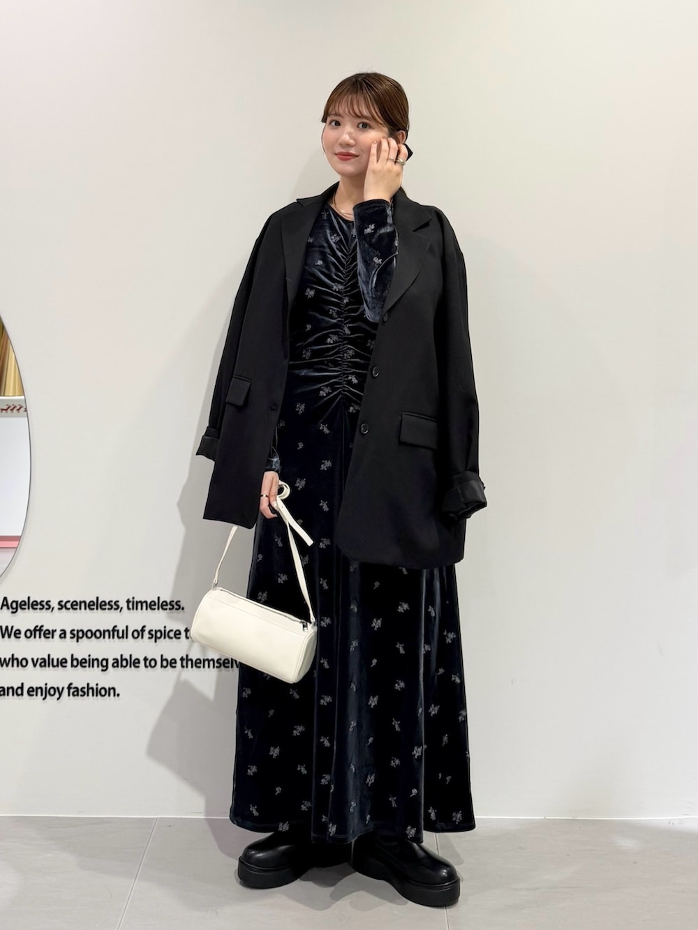 グレー系のワンピース、ブラック系のブーツ、ブラック系のその他アウターを着用したレディースの秋コーディネートの2枚目の写真