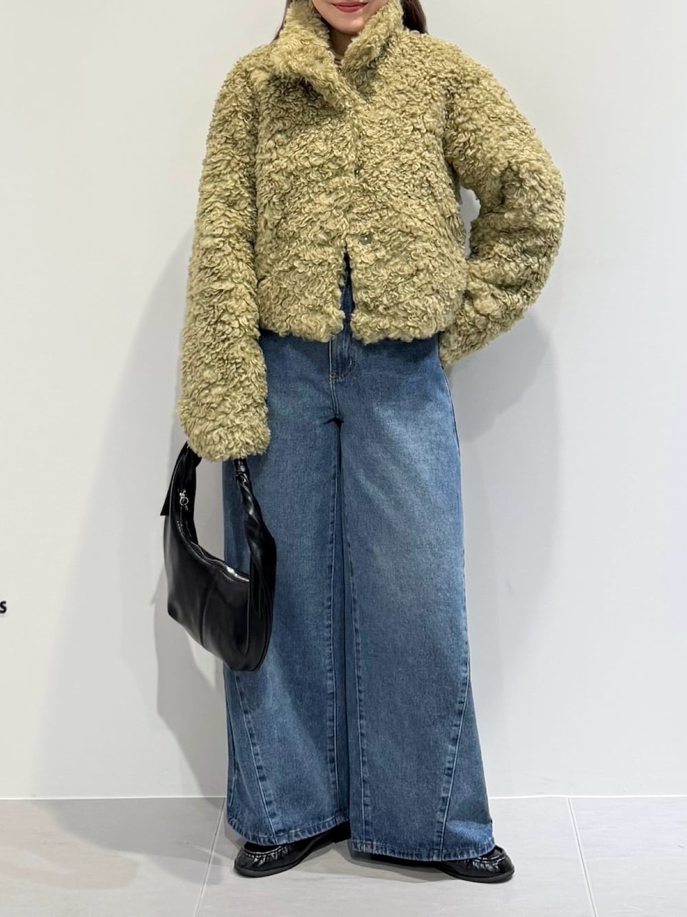 グリーン系のその他アウター、ブルー系のデニムパンツ、ブラック系のハンドバッグを着用したレディースの秋コーディネートの2枚目の写真