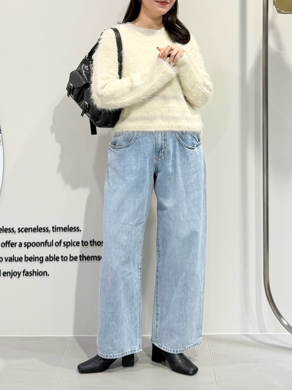 ホワイト系のニット/セーター、ブルー系のデニムパンツ、ブラウン系のショルダーバッグを着用したレディースの冬コーディネートの4枚目の写真