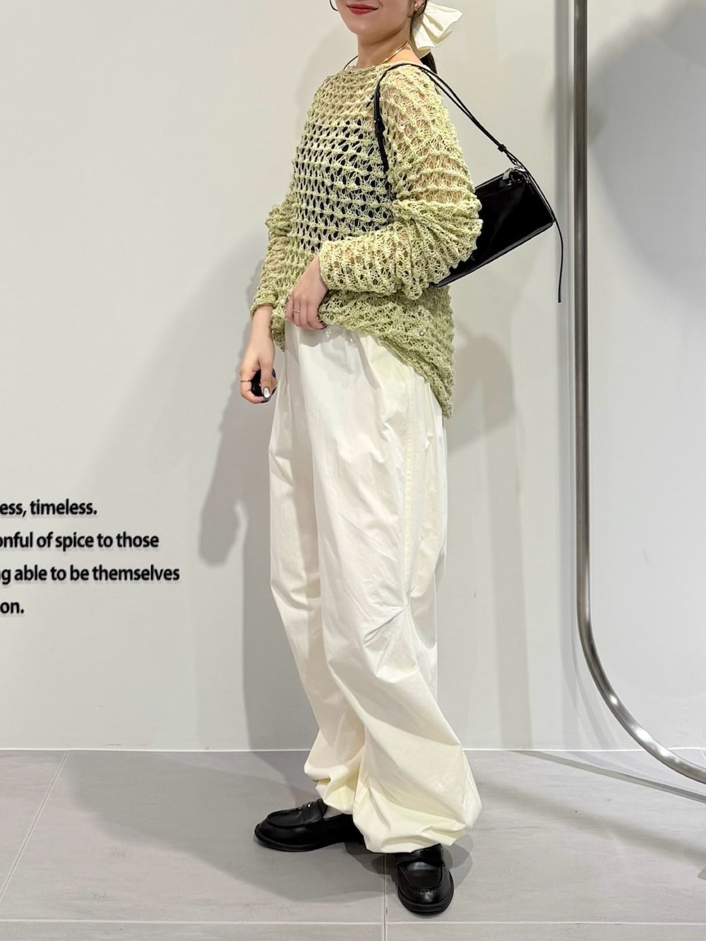 グリーン系のニット/セーター、ホワイト系のキャミソール、ホワイト系のその他パンツを着用したレディースの春コーディネートの2枚目の写真