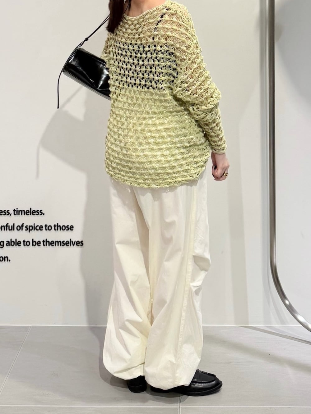 グリーン系のニット/セーター、ホワイト系のキャミソール、ホワイト系のその他パンツを着用したレディースの春コーディネートの4枚目の写真