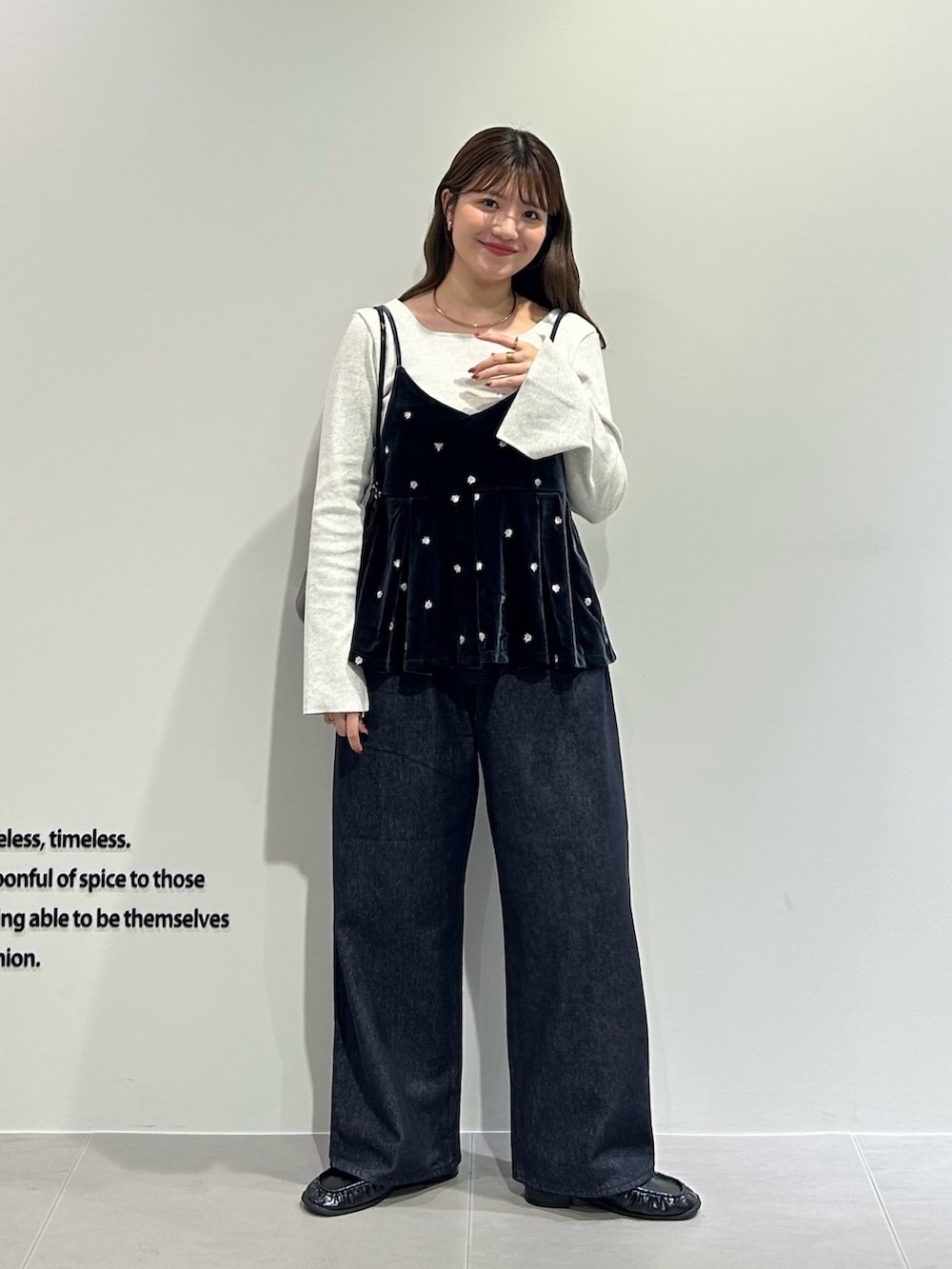 グレー系のキャミソール、グレー系のTシャツ/カットソー、ブルー系のデニムパンツを着用したレディースの秋コーディネートの5枚目の写真