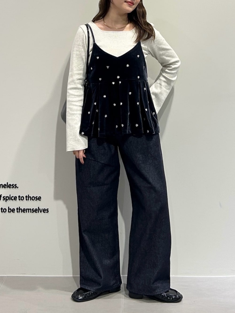 グレー系のキャミソール、グレー系のTシャツ/カットソー、ブルー系のデニムパンツを着用したレディースの秋コーディネートの2枚目の写真