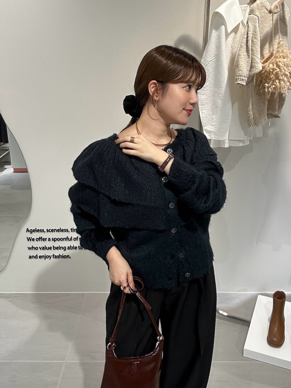 ブラック系のブーツ、ブラウン系のショルダーバッグ、ブラック系のその他パンツを着用したレディースの秋コーディネートの4枚目の写真