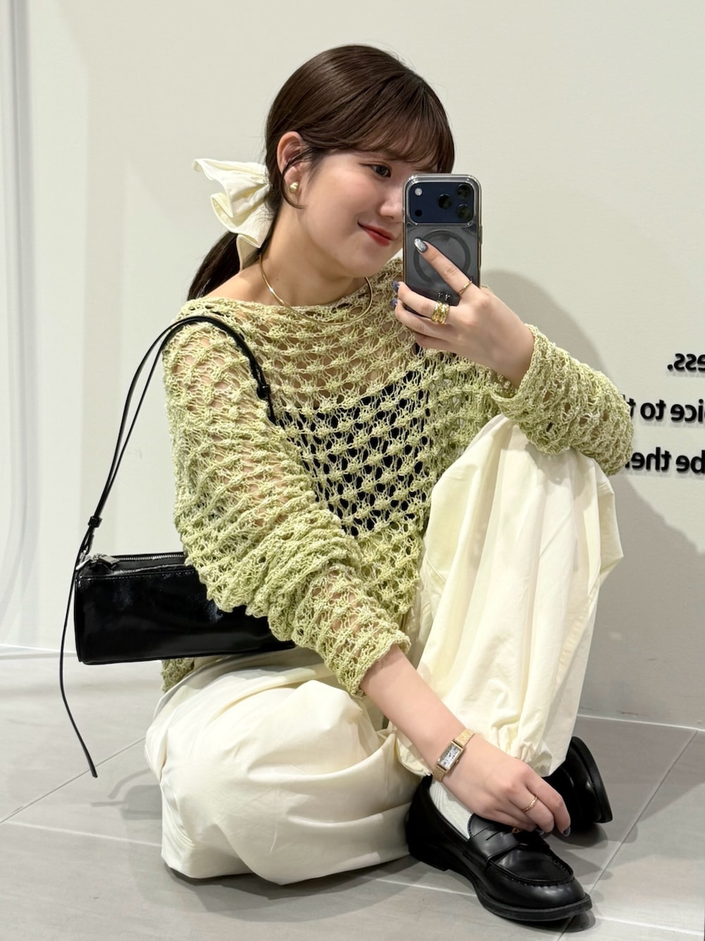 グリーン系のニット/セーター、ホワイト系のキャミソール、ホワイト系のその他パンツを着用したレディースの春コーディネートの3枚目の写真