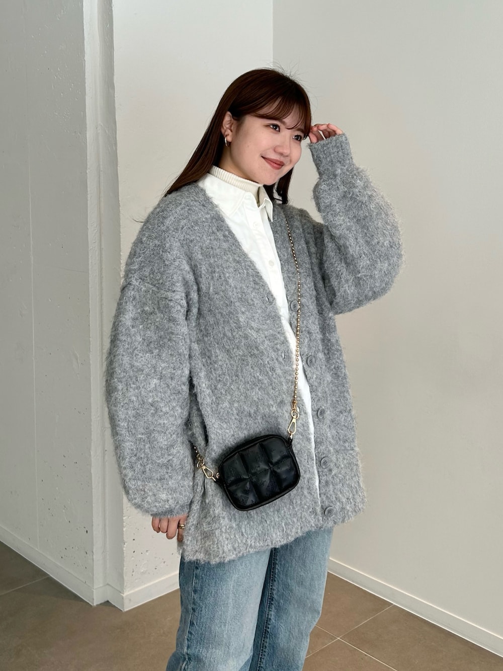 グレー系のカーディガン/ボレロ、ブルー系のデニムパンツ、ブラック系のブーツを着用したレディースの冬コーディネートの3枚目の写真