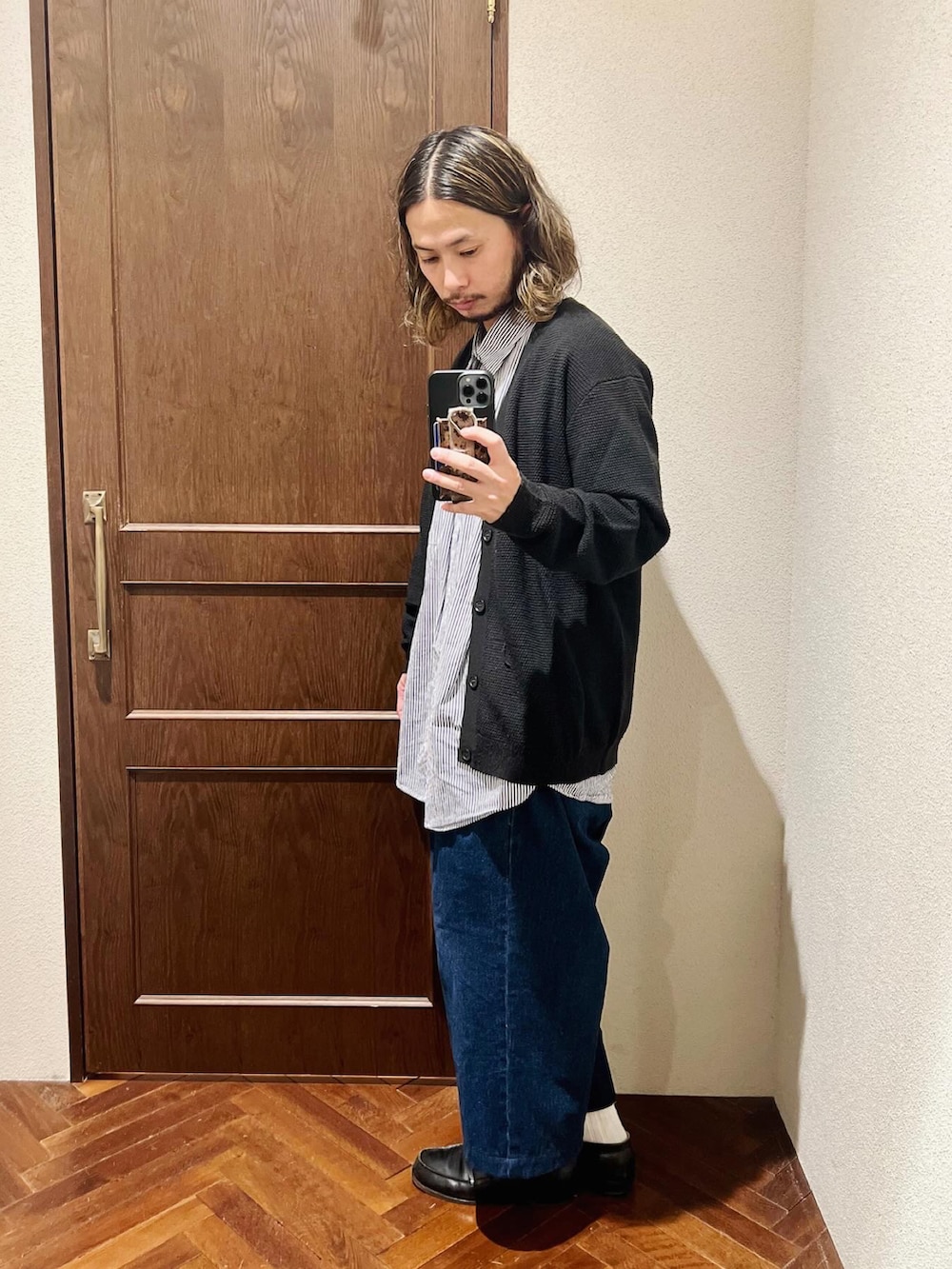 ブラック系のカーディガン/ボレロ、ブルー系のシャツ/ブラウス、ブルー系のデニムパンツを着用したメンズの冬コーディネートの3枚目の写真