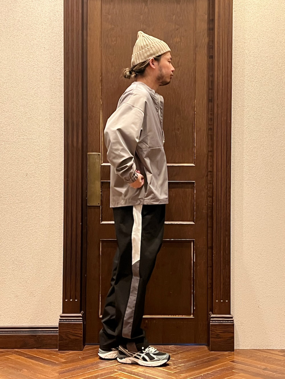 「プルオーバー、ナイロンジャケット、トラックパンツ、ニット帽、アシックス、スポーツミックス、大人カジュアル、モノトーン、モノトーンコーデ、重ね着、レイヤードスタイル、休日コーデ、公園スタイル、ストリートコーデ、ストリートMIX」｜「RACALのRACAL/別注 standard knit cap（ニットキャップ/ビーニー、ブラウン系）」を使った、窪田 孝之さん（メンズ・170cm）の夏コーディネートの3枚目の写真
