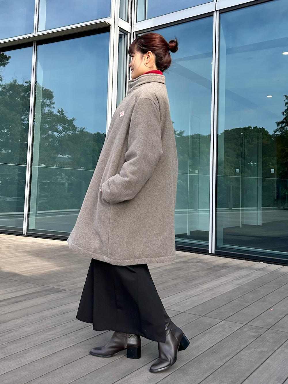 ブラック系のワンピース、レッド系のニット/セーター、ベージュ系のダウンジャケット/コートを着用したレディースの秋コーディネートの3枚目の写真