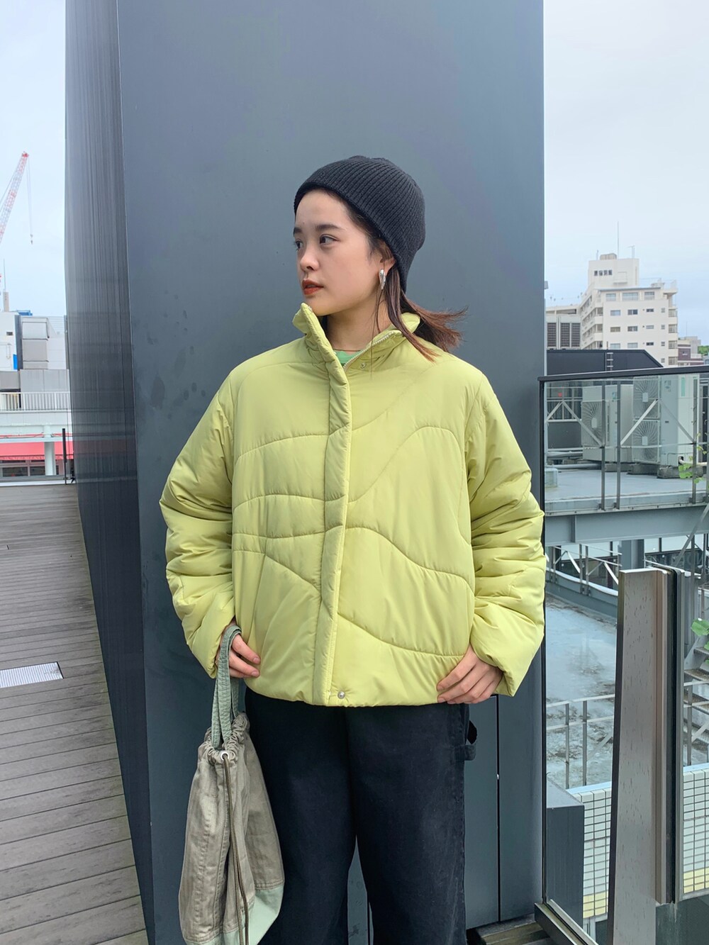 イエロー系のダウンジャケット/コート、ブラック系のその他パンツを着用したレディースの秋コーディネートの3枚目の写真