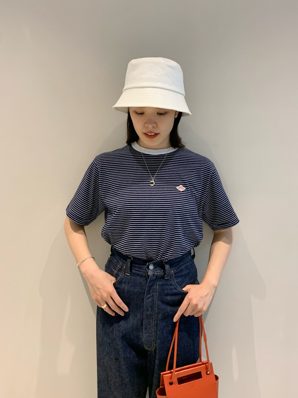 レッド系のトートバッグ、ブルー系のデニムパンツ、その他のTシャツ/カットソーを着用したレディースの春コーディネートの3枚目の写真