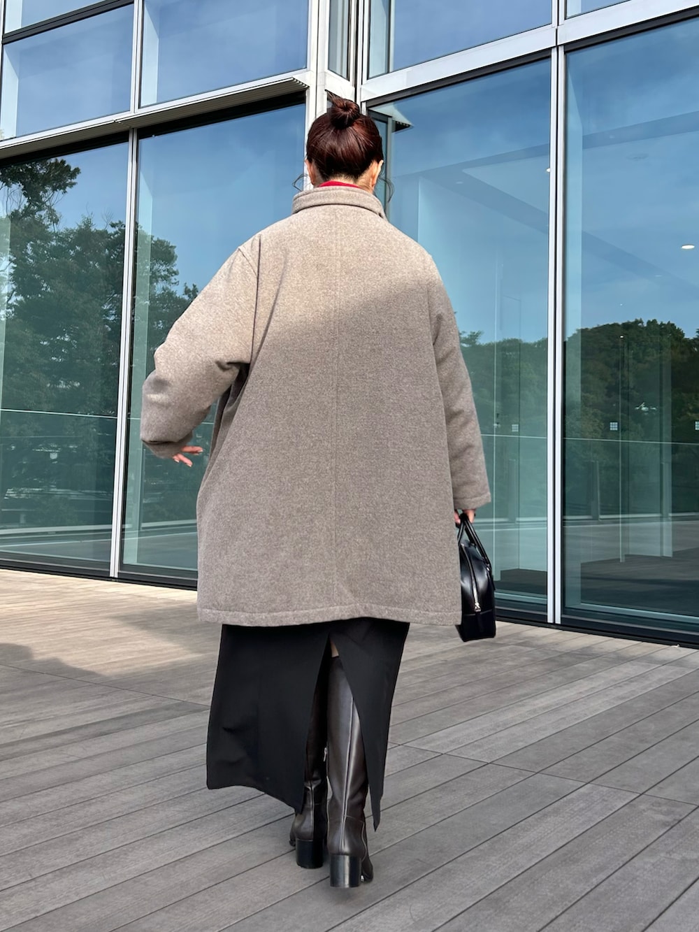 ブラック系のワンピース、レッド系のニット/セーター、ベージュ系のダウンジャケット/コートを着用したレディースの秋コーディネートの4枚目の写真