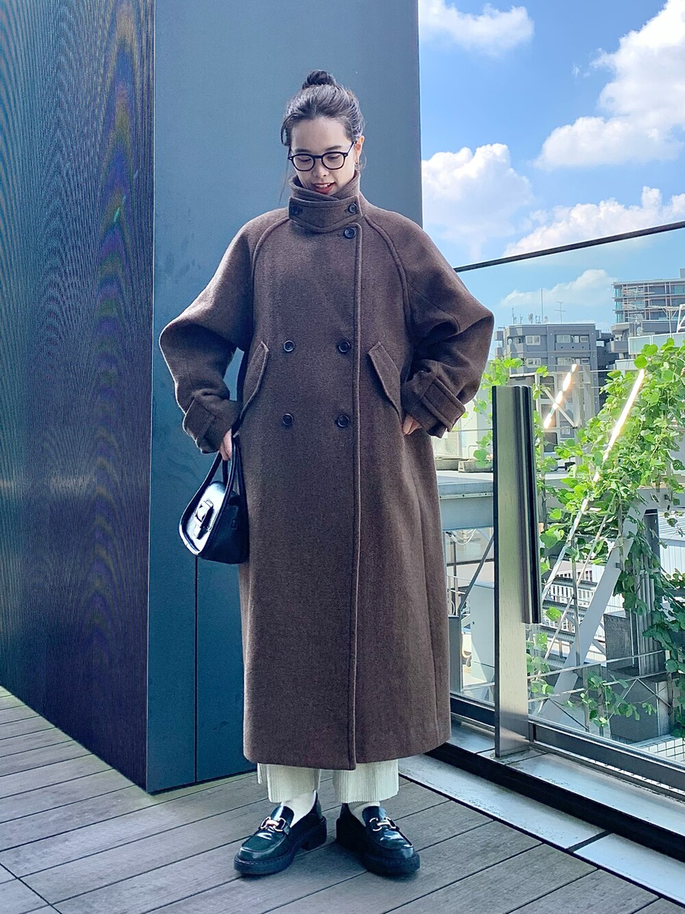 ブラック系のショルダーバッグ、ブラウン系のその他アウター、ブラック系のニット/セーターを着用したレディースの秋コーディネートの2枚目の写真