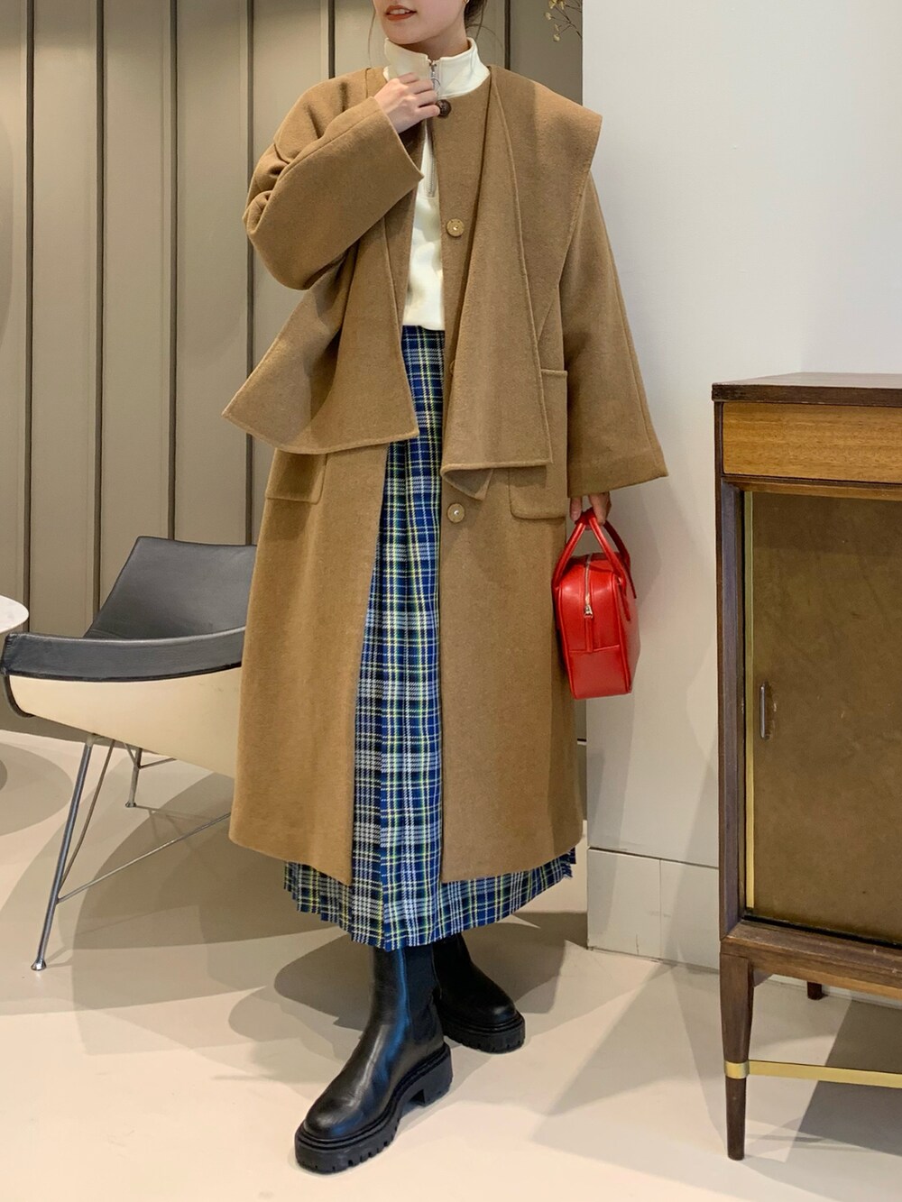 ブラウン系のノーカラーコート、ブルー系のスカートを着用したレディースの秋コーディネートの2枚目の写真