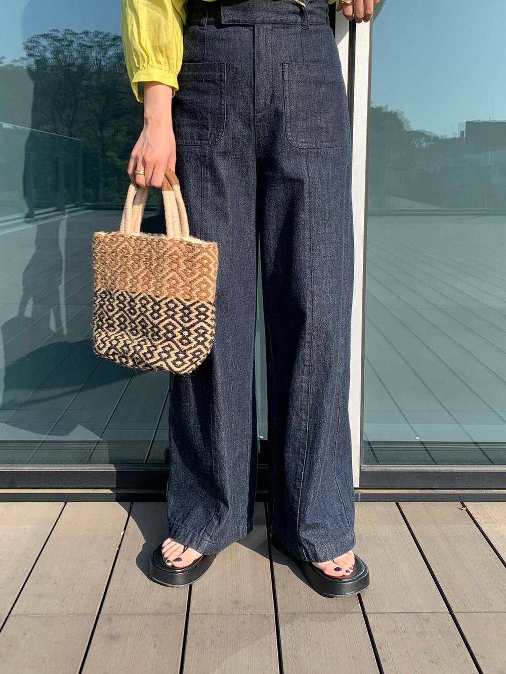 イエロー系のシャツ/ブラウス、ブラウン系のかごバッグ、ブラック系のその他シューズを着用したレディースの春コーディネートの3枚目の写真