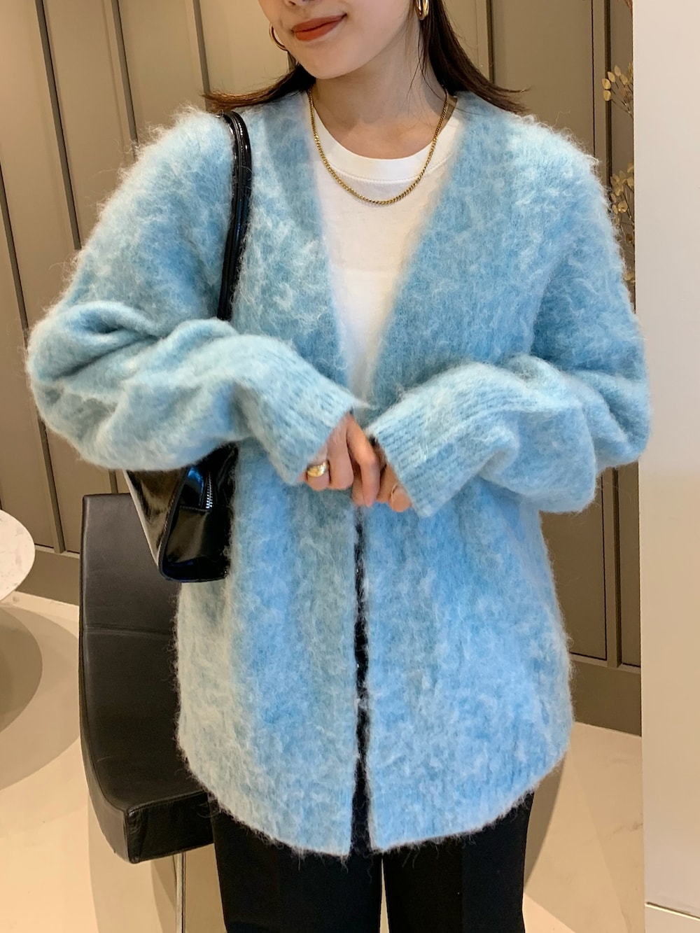 ブルー系のカーディガン/ボレロ、ブラック系のその他パンツ、ブラック系のトートバッグを着用したレディースの秋コーディネートの2枚目の写真