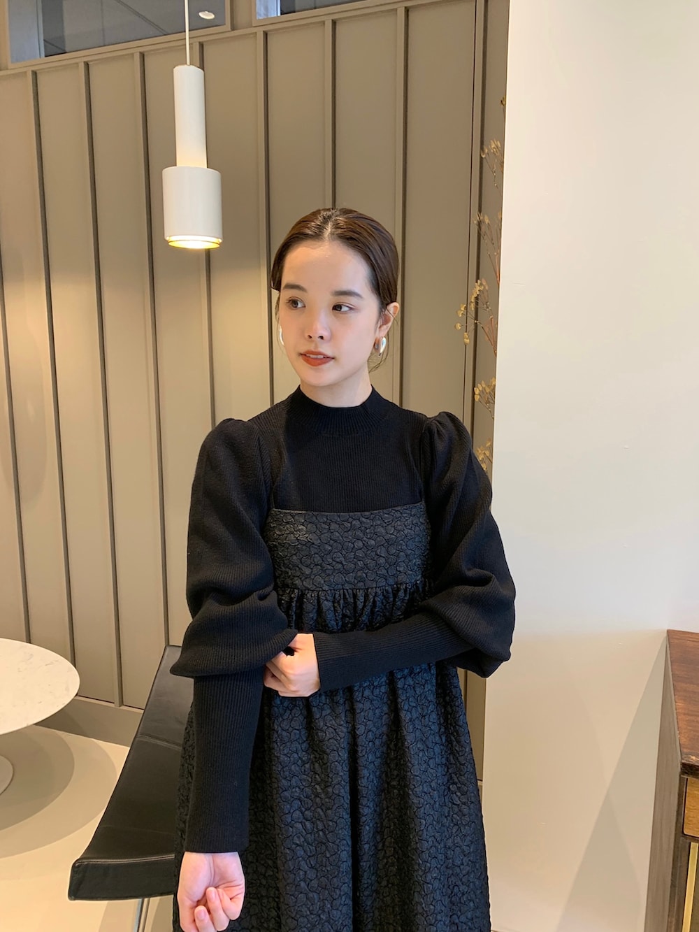 ブラック系のニット/セーター、ブラック系のワンピース、グリーン系のメッセンジャーバッグを着用したレディースの秋コーディネートの2枚目の写真