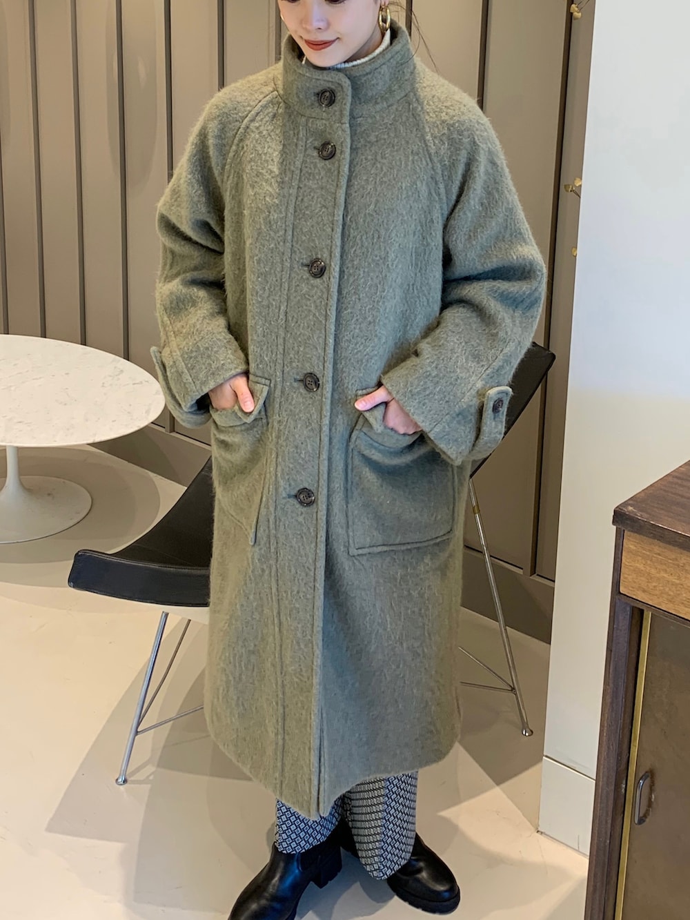 ブラック系のショルダーバッグ、グリーン系のその他アウターを着用したレディースの秋コーディネートの2枚目の写真