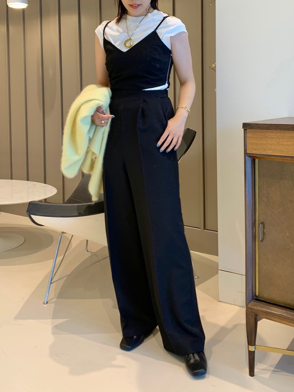 ブラック系のサロペット/オーバーオール、イエロー系のニット/セーターを着用したレディースの夏コーディネートの2枚目の写真