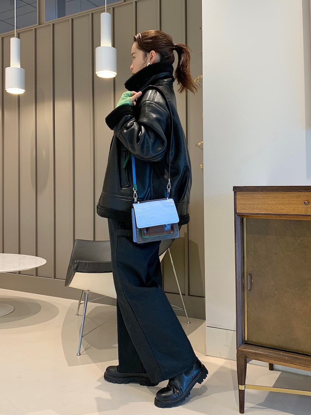 ブラック系のムートンコート、ブラック系のその他パンツ、その他のショルダーバッグを着用したレディースの秋コーディネートの2枚目の写真