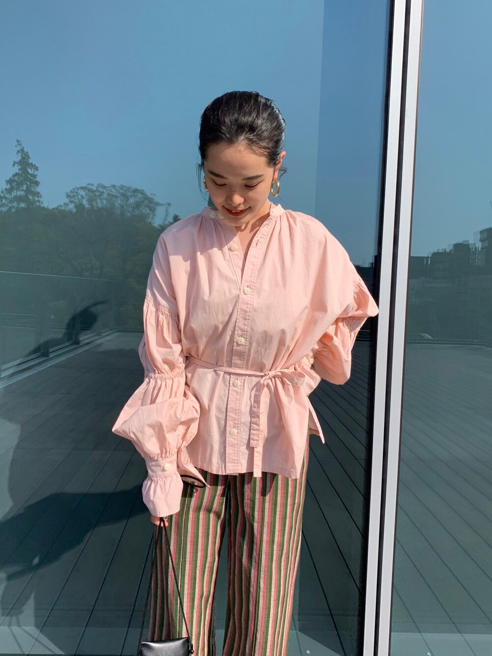 ブラック系のショルダーバッグ、レッド系のシャツ/ブラウスを着用したレディースの春コーディネートの2枚目の写真