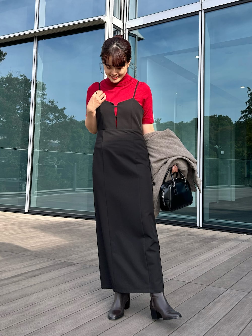 ブラック系のワンピース、レッド系のニット/セーター、ベージュ系のダウンジャケット/コートを着用したレディースの秋コーディネートの5枚目の写真