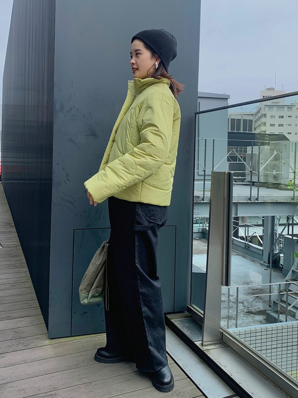 イエロー系のダウンジャケット/コート、ブラック系のその他パンツを着用したレディースの秋コーディネートの2枚目の写真