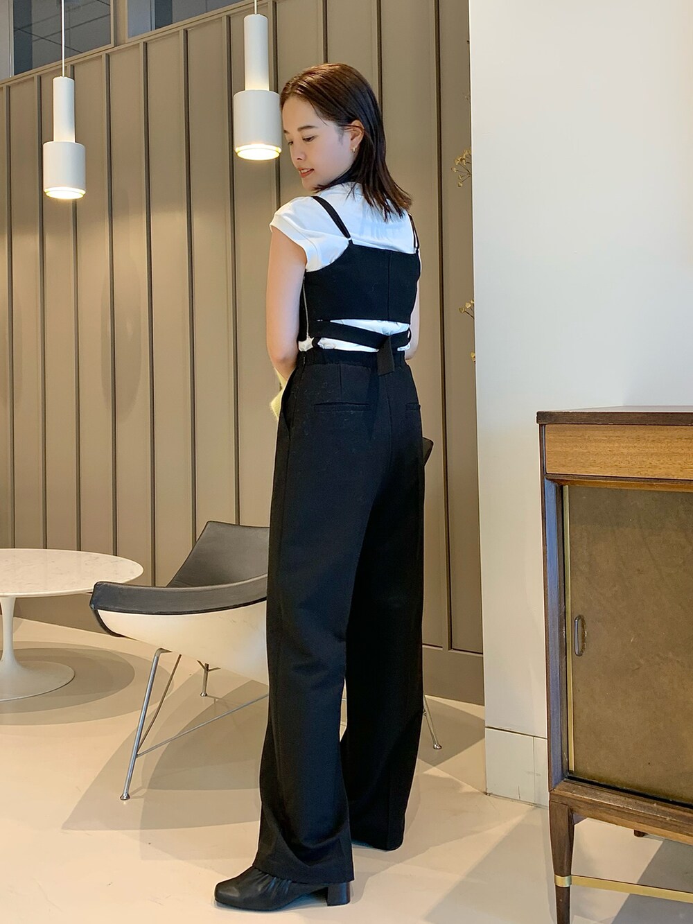 ブラック系のサロペット/オーバーオール、イエロー系のニット/セーターを着用したレディースの夏コーディネートの3枚目の写真