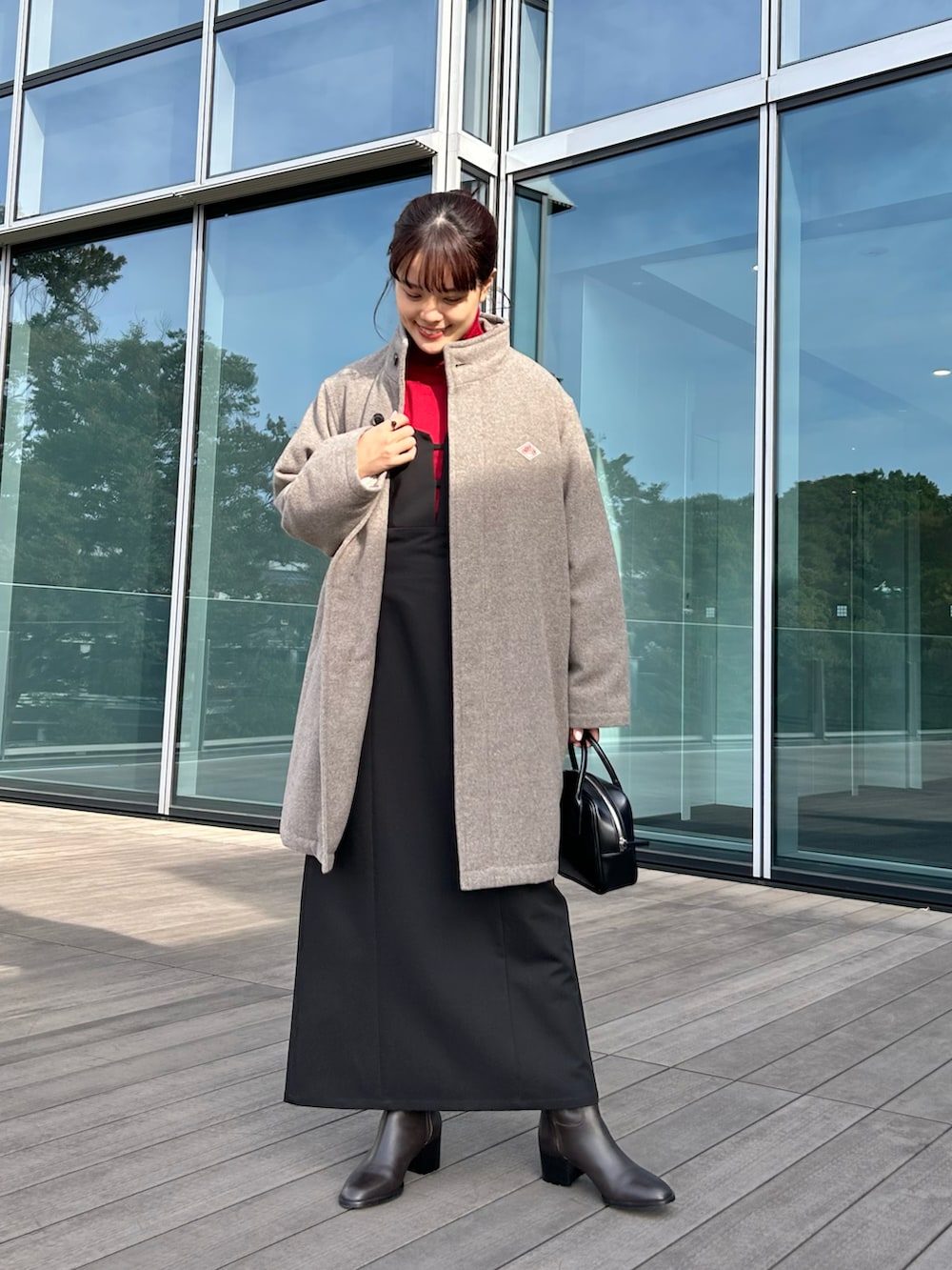 ブラック系のワンピース、レッド系のニット/セーター、ベージュ系のダウンジャケット/コートを着用したレディースの秋コーディネートの2枚目の写真