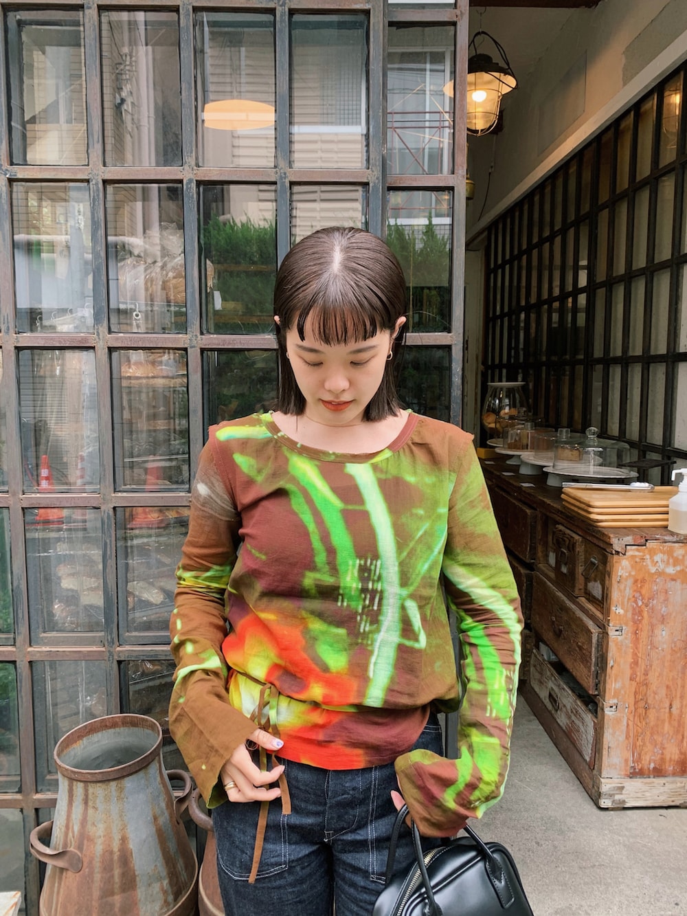 ブラック系のシャツ/ブラウス、ゴールド系のピアス（両耳用）を着用したレディースの春コーディネートの2枚目の写真