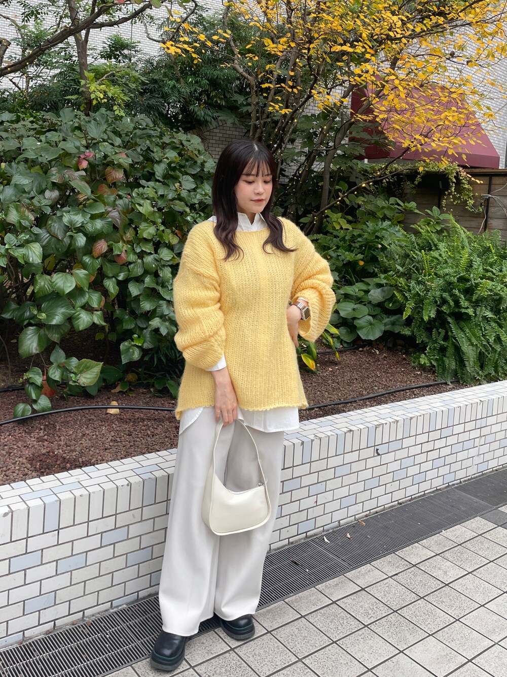 イエロー系のニット/セーターを着用したレディースの冬コーディネートの3枚目の写真