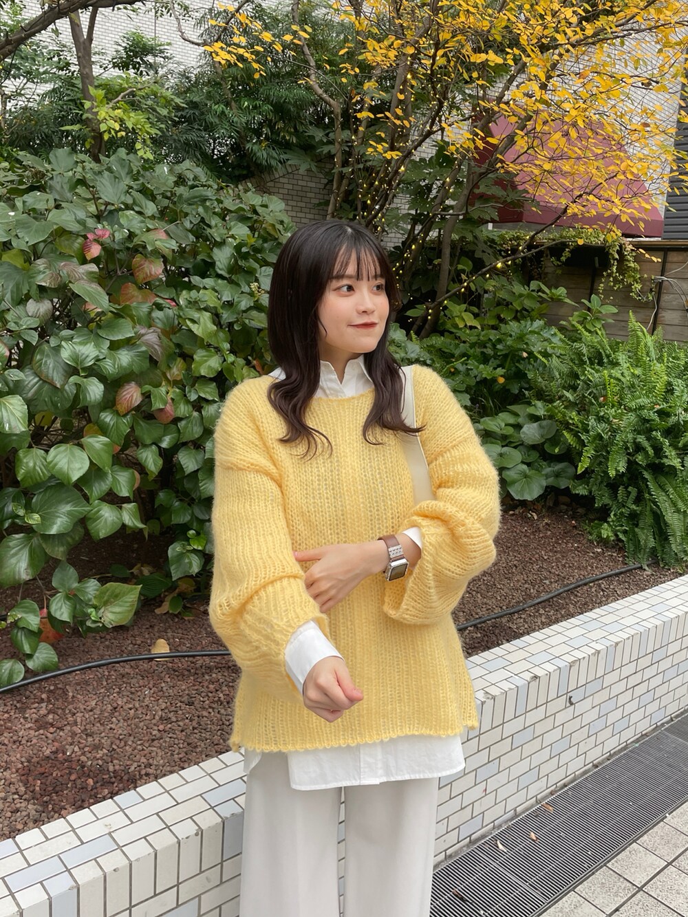 イエロー系のニット/セーターを着用したレディースの冬コーディネートの2枚目の写真