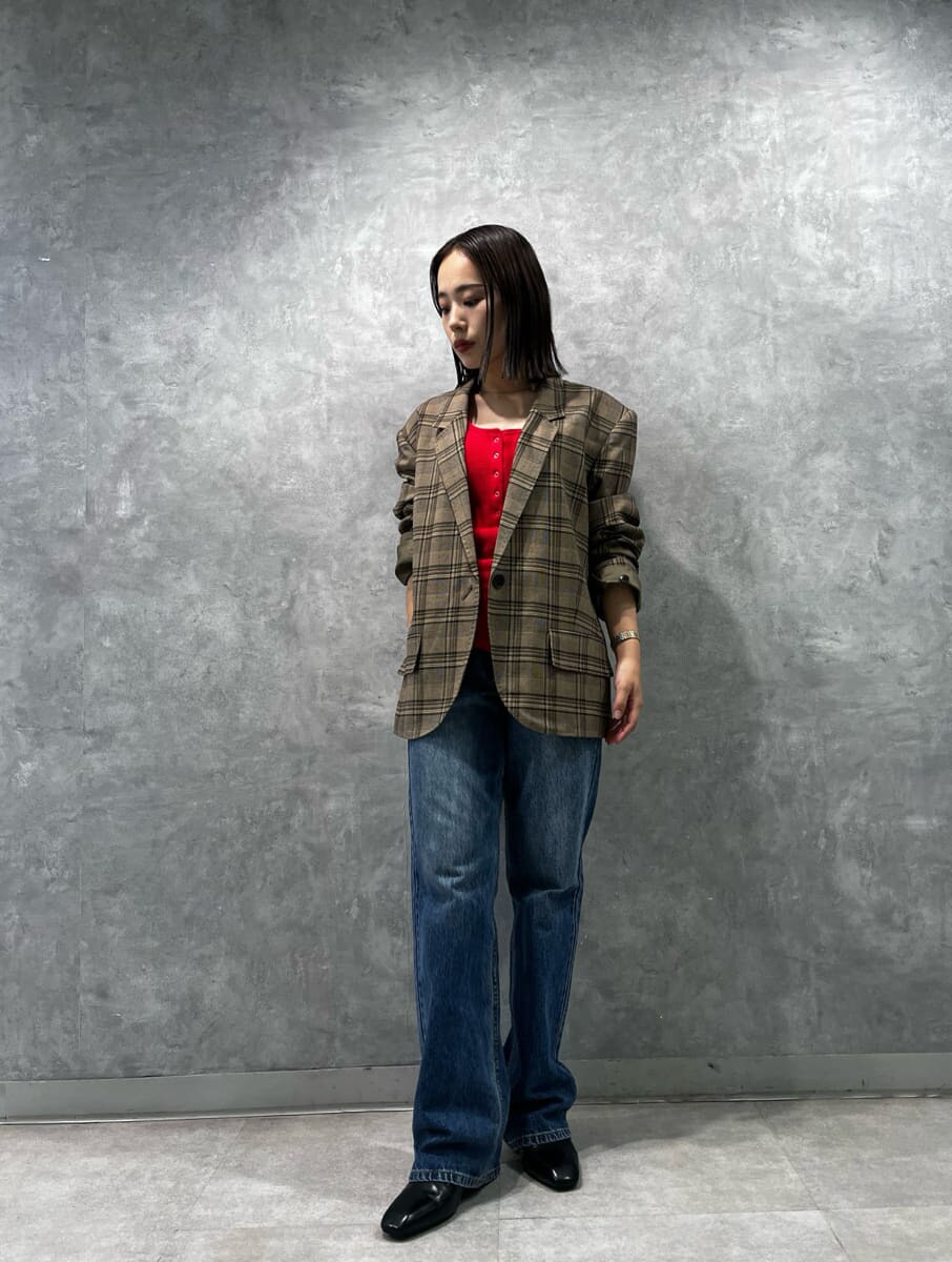 レッド系のタンクトップ、ブルー系のデニムパンツを着用したレディースの秋コーディネートの2枚目の写真