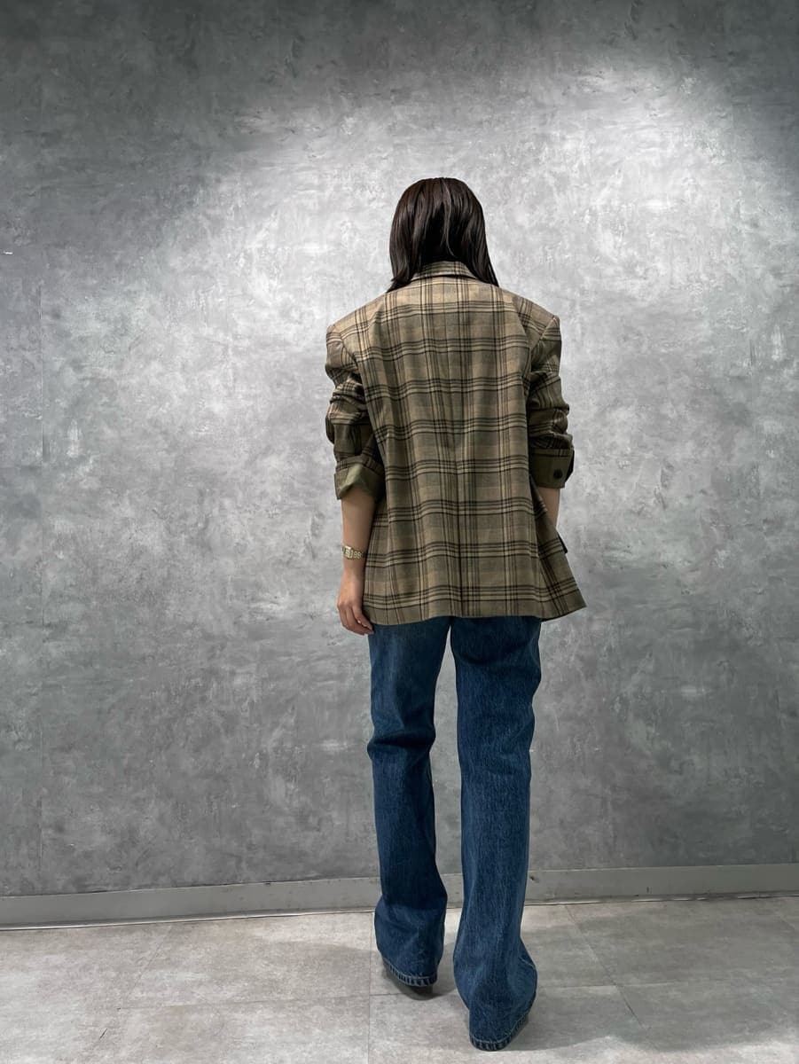 レッド系のタンクトップ、ブルー系のデニムパンツを着用したレディースの秋コーディネートの3枚目の写真