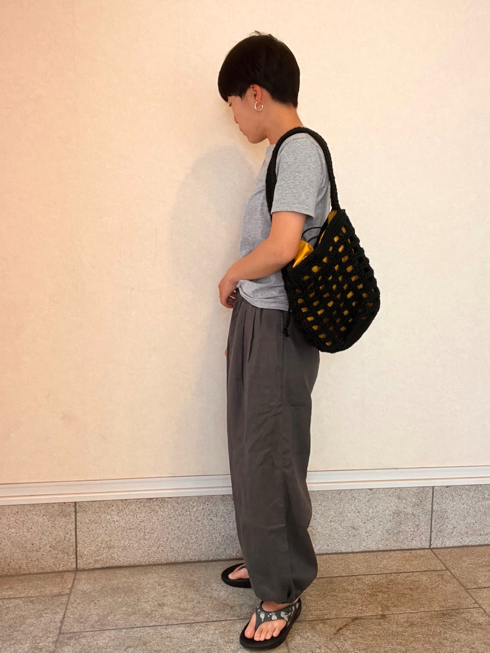 ブラック系のTシャツ/カットソー、グレー系のその他パンツ、ブラック系のバッグを着用したレディースの春コーディネートの2枚目の写真