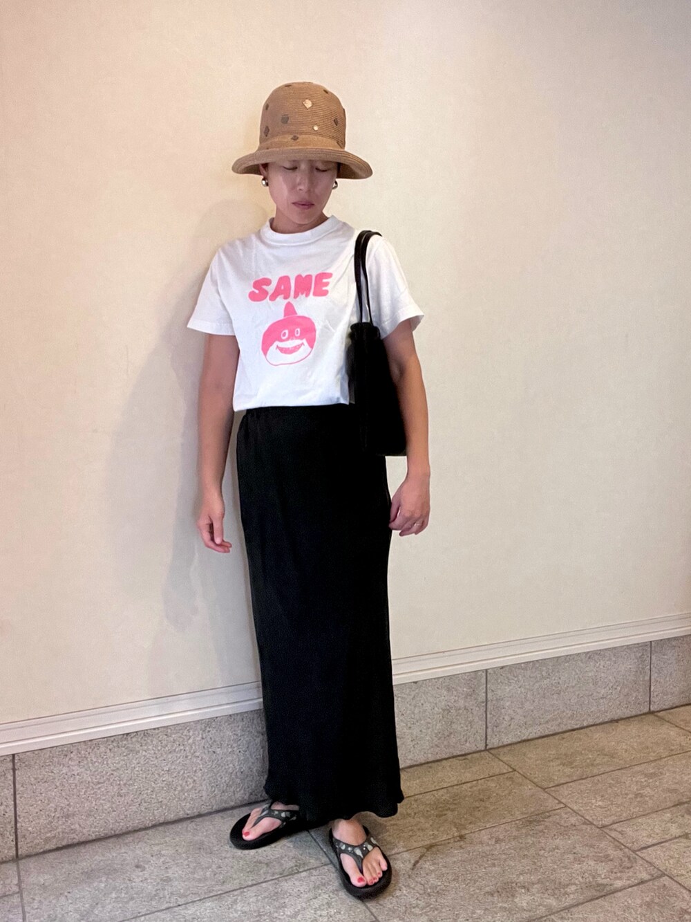 ホワイト系のTシャツ/カットソー、グレー系のスカート、ブラック系のトートバッグを着用したレディースの夏コーディネートの2枚目の写真