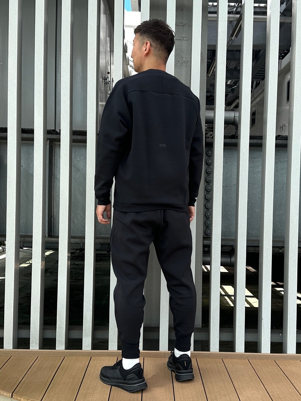 ブラック系のスウェット、ブラック系のその他パンツ、ブラック系のスニーカーを着用したメンズの秋コーディネートの3枚目の写真