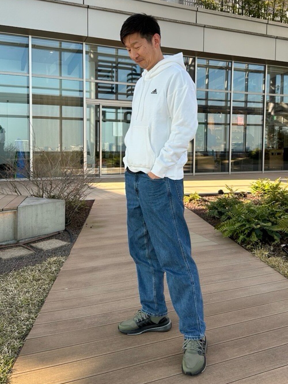 グリーン系のスニーカー、ホワイト系のパーカーを着用したメンズの冬コーディネートの2枚目の写真